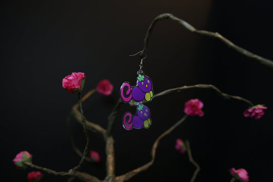 Purple Gralockamay Earrings dangling from a paper Mache tree.