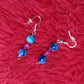 Blue Drop Earrings with two blue speceld beads one on the top and bottom. In between is a transparent small purple bead then a magenta glass bead and a purple glass bead.